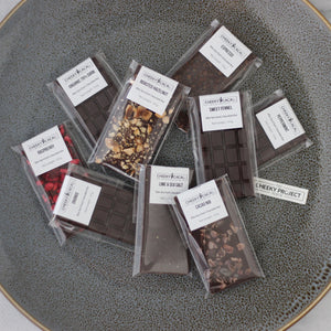 Assorted bite size chocolate bars in clear packaging on a gray plate with a marble background